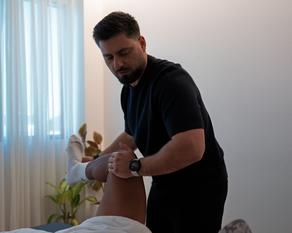Andre Machado, sports chiropractor, assessing a patient&rsquo;s hip and knee